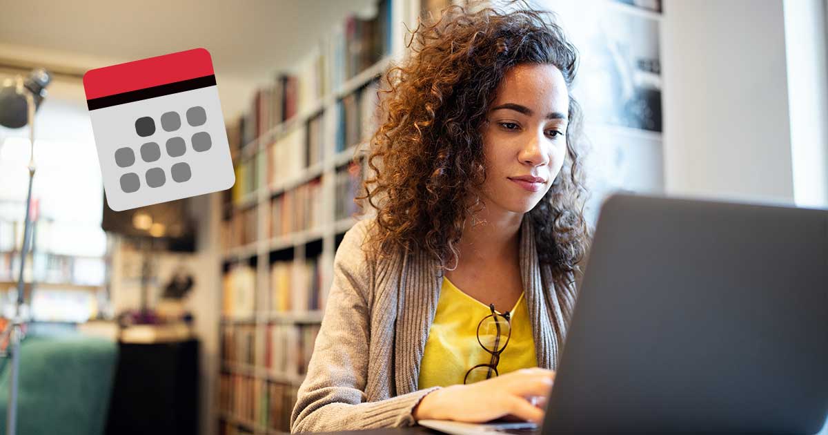 Eine junge Frau sitzt am Laptop und tippt