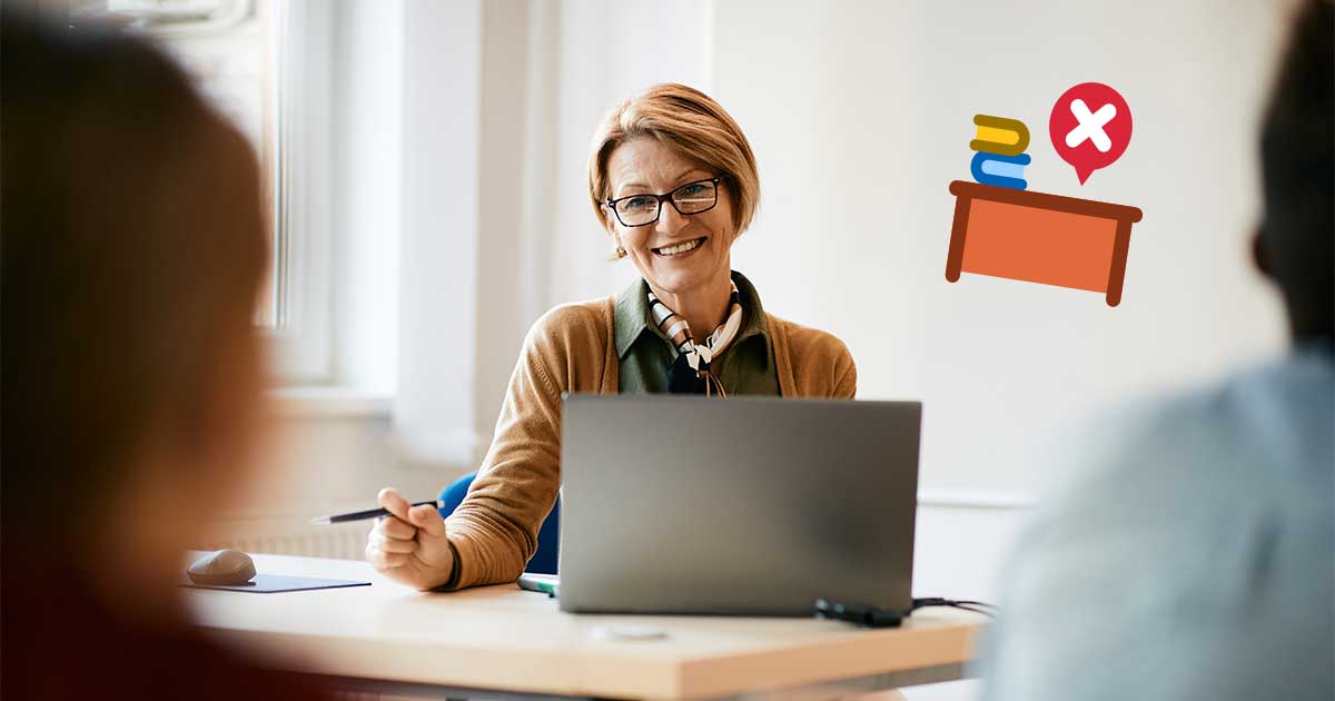 Eine Frau sitzt im Klassenzimmer am Laptop