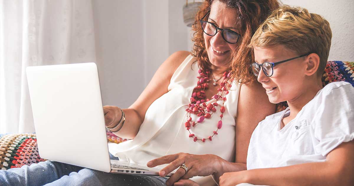 Eine Mutter schaut mit ihrem Sohn auf einen Laptop