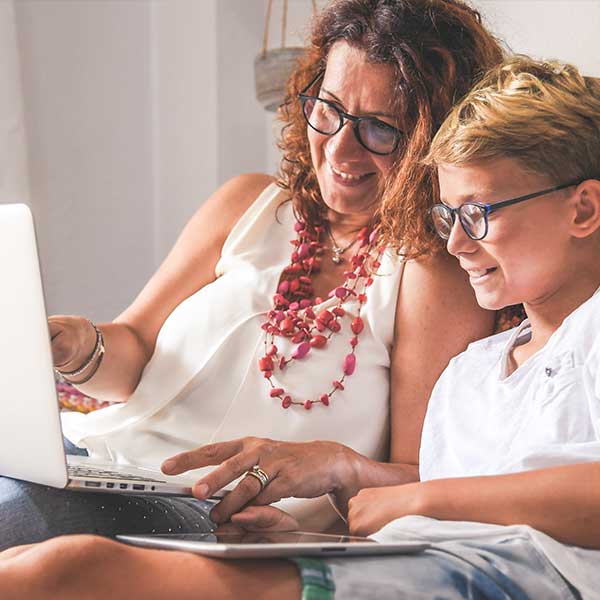 Eine Mutter schaut mit ihrem Sohn auf einen Laptop